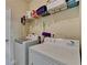 Efficient laundry area with modern washer and dryer, storage shelf, and utility sink at 1815 Sharon Rd, Cumming, GA 30041