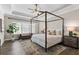 Bedroom with four poster bed, wood floors, tray ceiling, and bench by the window at 6763 Encore Blvd, Atlanta, GA 30328
