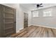 Cozy bedroom features wood-look flooring, natural light, a ceiling fan, and two entry doors at 6763 Encore Blvd, Atlanta, GA 30328