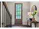 Charming entryway featuring a front door view, decorative mirror, lamp, wooden table, and hardwood floors at 6763 Encore Blvd, Atlanta, GA 30328