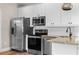 Well-equipped kitchen with stainless steel appliances, granite countertops, and white cabinetry at 6763 Encore Blvd, Atlanta, GA 30328