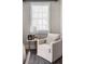 Relaxing living room with a comfy chair, side table, and natural light streaming through the window at 6763 Encore Blvd, Atlanta, GA 30328