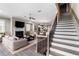Open concept living room with fireplace, staircase, and views to the kitchen at 6763 Encore Blvd, Atlanta, GA 30328
