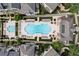 Aerial view of a community pool, featuring lounge chairs, tables, umbrellas, and lush greenery at 6763 Encore Blvd, Atlanta, GA 30328