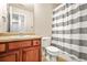 Bathroom featuring striped shower curtain, wooden vanity, and neutral color scheme offers a simple and functional design at 1326 Castleberry Dr, Buford, GA 30518