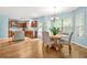 Bright dining area featuring wood floors, a cozy table, and a view of the kitchen and backyard at 1326 Castleberry Dr, Buford, GA 30518