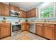 Cozy kitchen featuring wood cabinets, stainless steel appliances, and a window view at 1326 Castleberry Dr, Buford, GA 30518