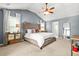 Spacious main bedroom with large upholstered headboard, ceiling fan and vaulted ceiling at 1326 Castleberry Dr, Buford, GA 30518
