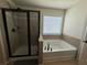 Bathroom featuring a tiled walk-in shower and a separate soaking tub with a window at 4305 Evans Farms Dr, Cumming, GA 30040