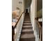 Carpeted stairway with white railings and wooden handrail leads upstairs from the main floor at 4305 Evans Farms Dr, Cumming, GA 30040