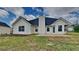 Backyard features a patio and the home's exterior with neat siding and dark roof at 5052 Hickory Cir, Ellenwood, GA 30294