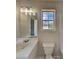 A bright bathroom features a single sink vanity, large mirror, and window at 5052 Hickory Cir, Ellenwood, GA 30294