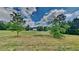 A view of the lush front yard showcasing mature trees and distant house at 5052 Hickory Cir, Ellenwood, GA 30294