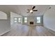 Spacious living room with a fireplace, vaulted ceiling, fan, and natural light from large windows at 5052 Hickory Cir, Ellenwood, GA 30294