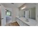 Bathroom features a double sink vanity, large mirror, and wood-look flooring, with neutral tones at 5052 Hickory Cir, Ellenwood, GA 30294