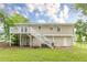 View of the backyard featuring a raised deck with stairs leading down to the grassy lawn at 5312 Brittany Trl, Atlanta, GA 30349
