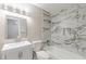 Bathroom featuring modern marble style tile, new vanity, tub, and fixtures at 5312 Brittany Trl, Atlanta, GA 30349