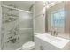 This renovated bathroom features a marble tiled shower and new vanity with a framed mirror at 5312 Brittany Trl, Atlanta, GA 30349