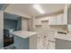 Modern kitchen boasts white cabinets, marble floors, and an island with seating at 5312 Brittany Trl, Atlanta, GA 30349