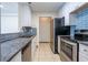 Galley kitchen featuring white cabinets, stainless steel appliances, and blue backsplash at 1074 Peachtree Ne Walk # B404, Atlanta, GA 30309