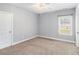A carpeted bedroom featuring a ceiling fan and a large window at 122 Gingers Way, Mcdonough, GA 30252