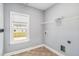 Simple laundry room with neutral walls, tile floors and view to the backyard at 122 Gingers Way, Mcdonough, GA 30252