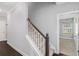 Carpeted staircase featuring white risers and a wooden handrail, leading to the upper level at 122 Gingers Way, Mcdonough, GA 30252