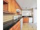 Kitchen with wood cabinets, white appliances, and black countertops at 1482 N Crossing Ne Cir, Atlanta, GA 30329