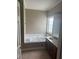 Bright bathroom with a soaking tub, window, vanity with sink and wooden cabinets at 21 Spring Folly Nw, Cartersville, GA 30121