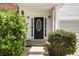 Elegant front door with sidelights, framed by lush, well-maintained landscaping at 40 Wimberly Way, Covington, GA 30016