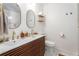 Modern bathroom showcasing a double sink vanity with wood accents, updated fixtures, and decorative mirrors at 962 Cardova Ne Dr, Atlanta, GA 30324