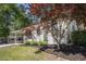Charming home exterior with a covered porch, manicured lawn, mature trees, and well-maintained landscaping at 962 Cardova Ne Dr, Atlanta, GA 30324