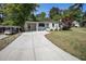 View of the home's exterior with lush lawn, long driveway, and convenient covered parking at 962 Cardova Ne Dr, Atlanta, GA 30324