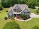Aerial view of a well-manicured home with lush greenery, a paved walkway and driveway at 161 Archstone Sq, Mcdonough, GA 30253