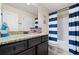 Bathroom featuring vanity with dark wood cabinets, granite countertop, and blue and white striped shower curtain at 161 Archstone Sq, Mcdonough, GA 30253
