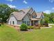 Beautiful two-story home with a manicured lawn, lush landscaping, and a welcoming front porch at 161 Archstone Sq, Mcdonough, GA 30253