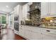 Modern kitchen with white cabinets, granite countertops, stainless steel appliances, and stylish backsplash at 161 Archstone Sq, Mcdonough, GA 30253
