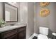 Well-maintained powder room featuring a dark vanity, granite countertop, and decorative accents at 161 Archstone Sq, Mcdonough, GA 30253