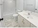 Pristine white bathroom featuring a bathtub, toilet, vanity, and marble tile flooring at 4345 Park Brooke Trce, Alpharetta, GA 30022