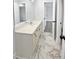 Bright bathroom with a white vanity, marble flooring, and a doorway that leads to another room at 4345 Park Brooke Trce, Alpharetta, GA 30022