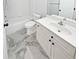 Bathroom featuring a white vanity and sink, marble flooring, and a shower and tub combination at 4345 Park Brooke Trce, Alpharetta, GA 30022