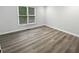 Cozy bedroom with a large window, neutral walls, and modern hardwood floors at 4345 Park Brooke Trce, Alpharetta, GA 30022