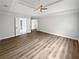 A spacious bedroom featuring a tray ceiling, ceiling fan, and light brown floors at 4345 Park Brooke Trce, Alpharetta, GA 30022