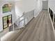 Hallway showcasing new wood floors, decorative railing, and natural light from large window at 4345 Park Brooke Trce, Alpharetta, GA 30022