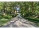 A long stone driveway with a gated entrance, bordered by mature trees leading to a beautiful home at 4375 Mount Paran Pkwy Nw, Atlanta, GA 30327