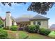 Back exterior with a chimney, siding, wooden deck, and luscious landscaping at 980 Ector Chase Nw, Kennesaw, GA 30152