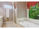 Bright bathroom with a soaking tub, walk-in shower, and decorative wallpaper at 980 Ector Chase Nw, Kennesaw, GA 30152