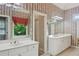 Bright bathroom featuring double vanity with white countertop, mirrors, and floral wallpaper at 980 Ector Chase Nw, Kennesaw, GA 30152