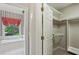 Walk-in closet with shelving leading to a bathroom with large tub and window at 980 Ector Chase Nw, Kennesaw, GA 30152