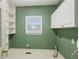 Laundry room with built in shelves, utility sink and white cabinets at 980 Ector Chase Nw, Kennesaw, GA 30152